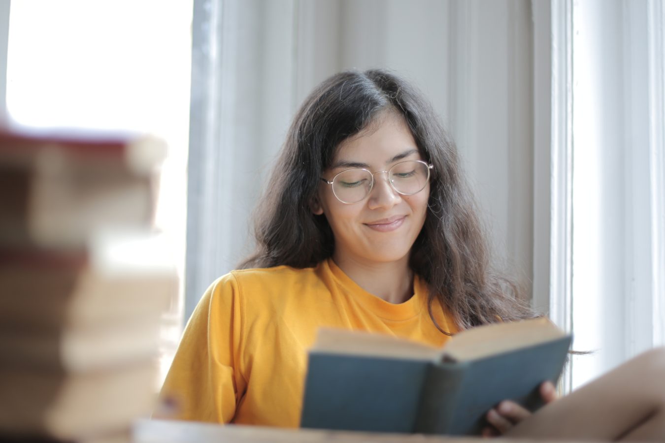 Lady with glasses on reading a book.