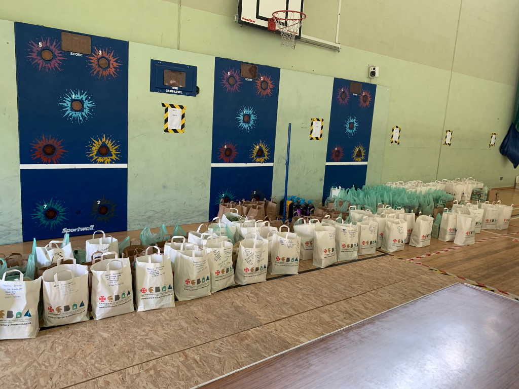 Lots of paper bags lined up on the floor in a sports hall