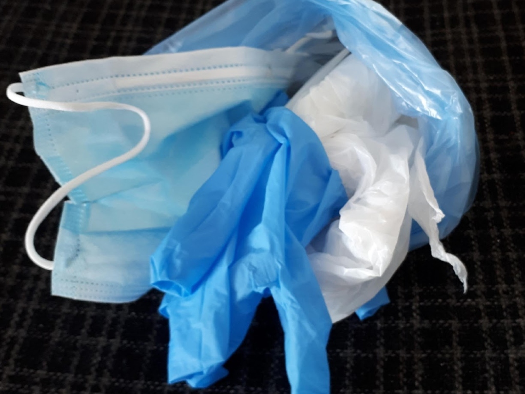 Blue face mask and gloves bundled into a bag