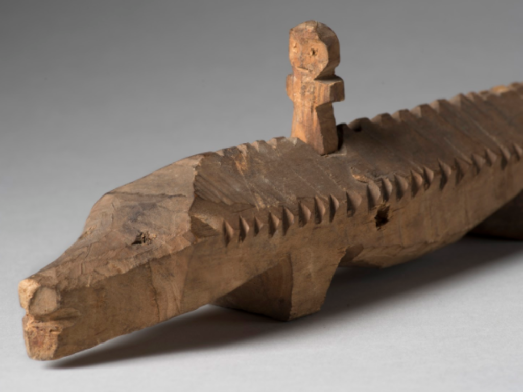 Wooden model sturgeon with figure on its back