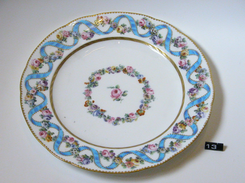 Plate with blue ribbon decoration around rim